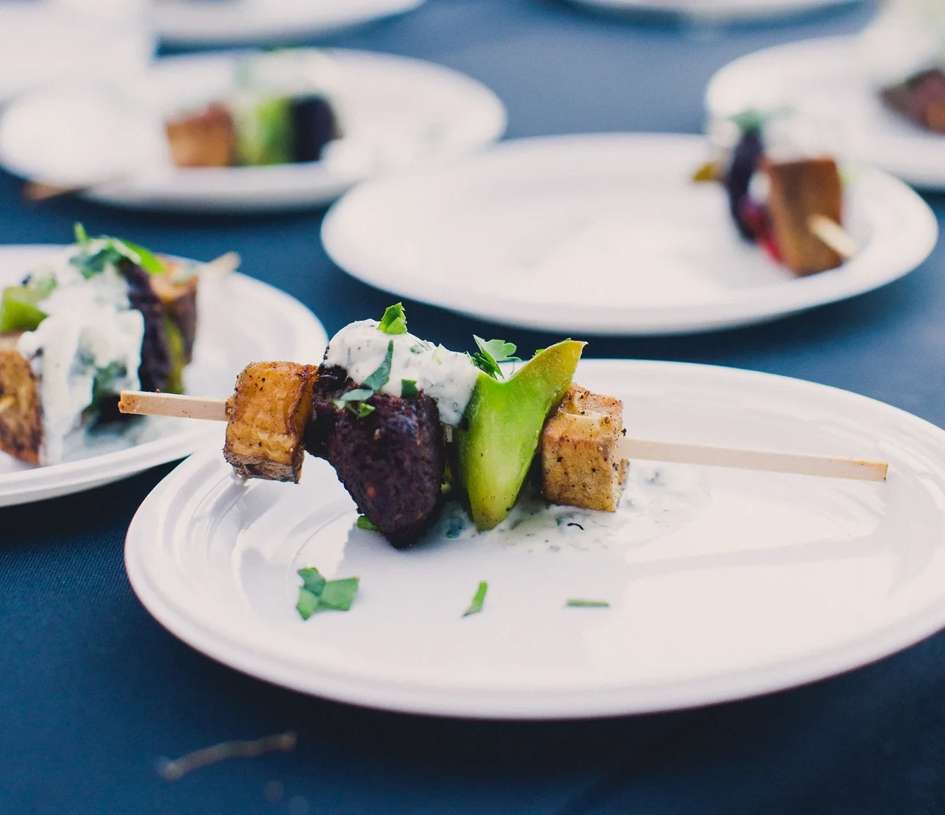 Passed appetizer skewers with meat, vegetables, and tzatziki at wedding catering